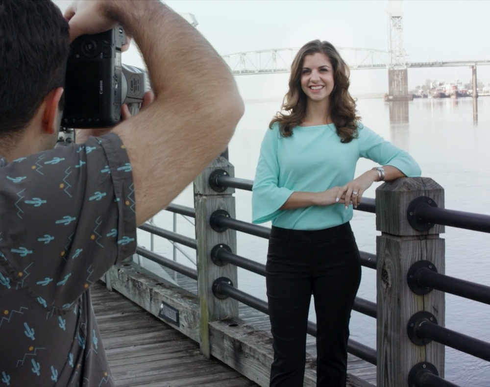 Woman posing on a bridge in front of a camera